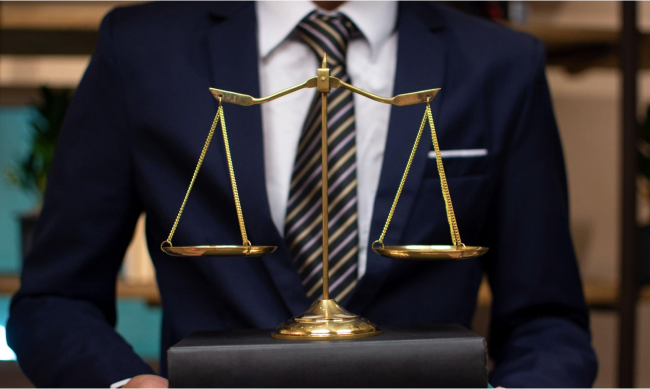 close-up of a commercial real estate lawyer in a suit holding a balanced golden scale