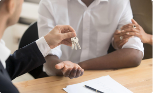 Real estate agent handing over keys to a new tenant after signing a commercial lease agreement