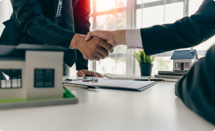 Handshake over a desk in a commercial real estate office symbolizing a successful zoning agreement