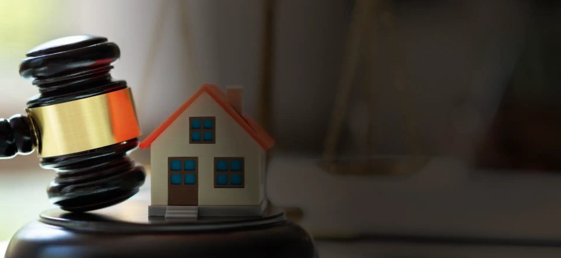 Family law represented as a gable and a miniature house and a balance faded in the background